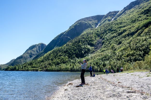 En ung jente har fått laks på kroken på en strålende dag i Vefsna.
