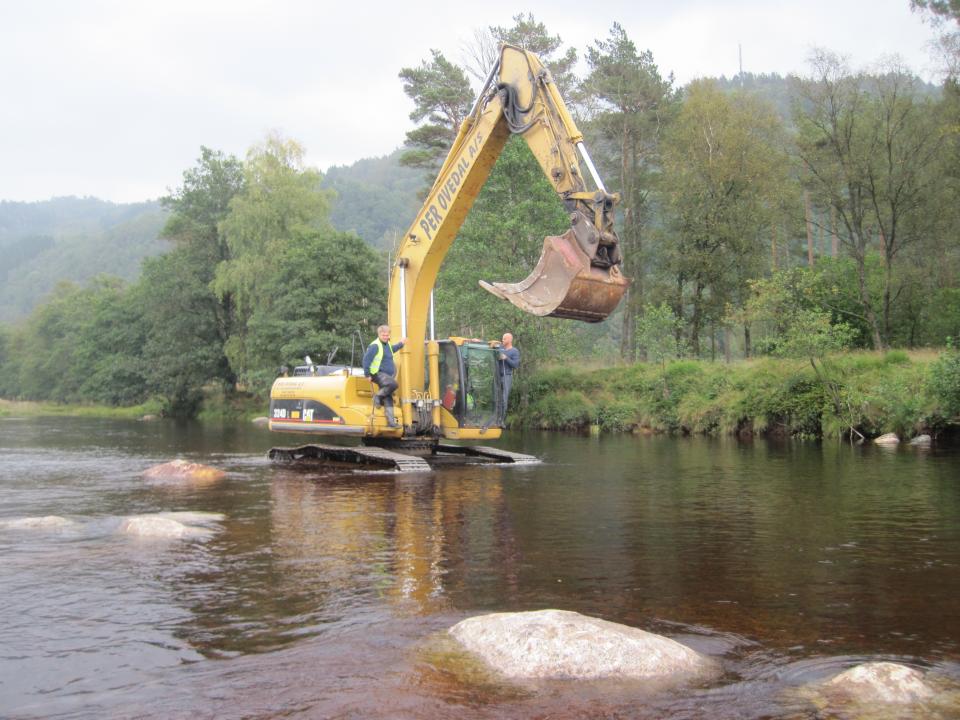 Biotopforbedrende tiltak ved Klosterøya i Kvina. Utlegging av store steiner for å skaffe skjul ved Klosterøya. Det er gjennomført en rekke tiltak for å bedre oppvekst og gyteforholdene i Kvina. På bilde: Per Ø. Grimsby Sira-Kvina kraftselskap og Roland Heibel i Økogrønt.